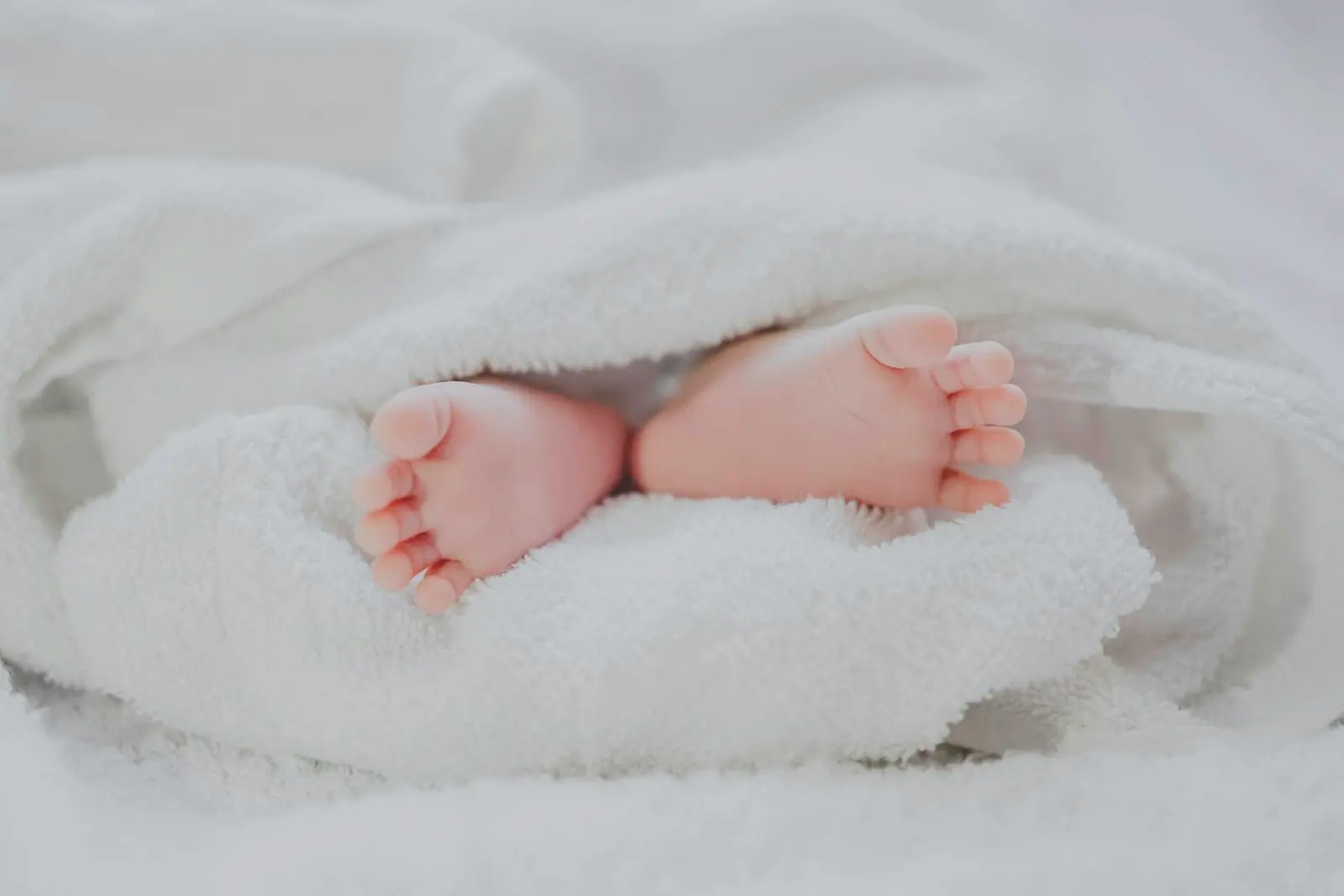 Neonato tenuto con cura nelle braccia